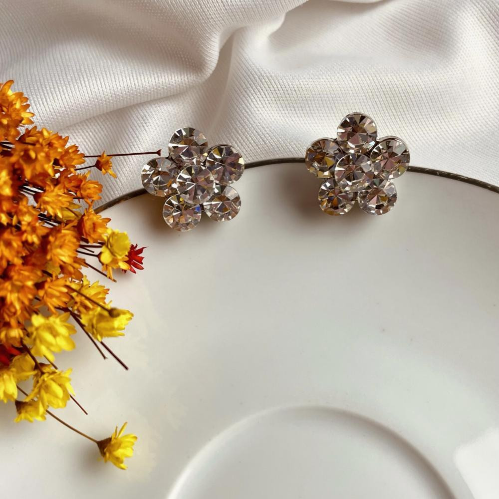 Brinco flor de strass banhado na cor paládio prata